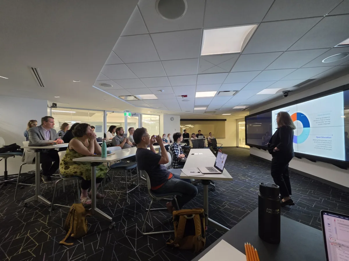 A speaker presenting a slide to a seated audience during one of the short talks at the workshop.